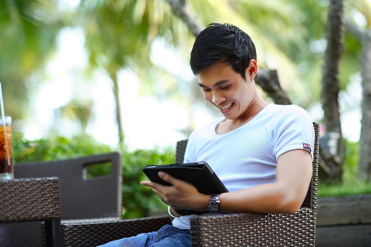 un homme regarde une tablette en extérieur